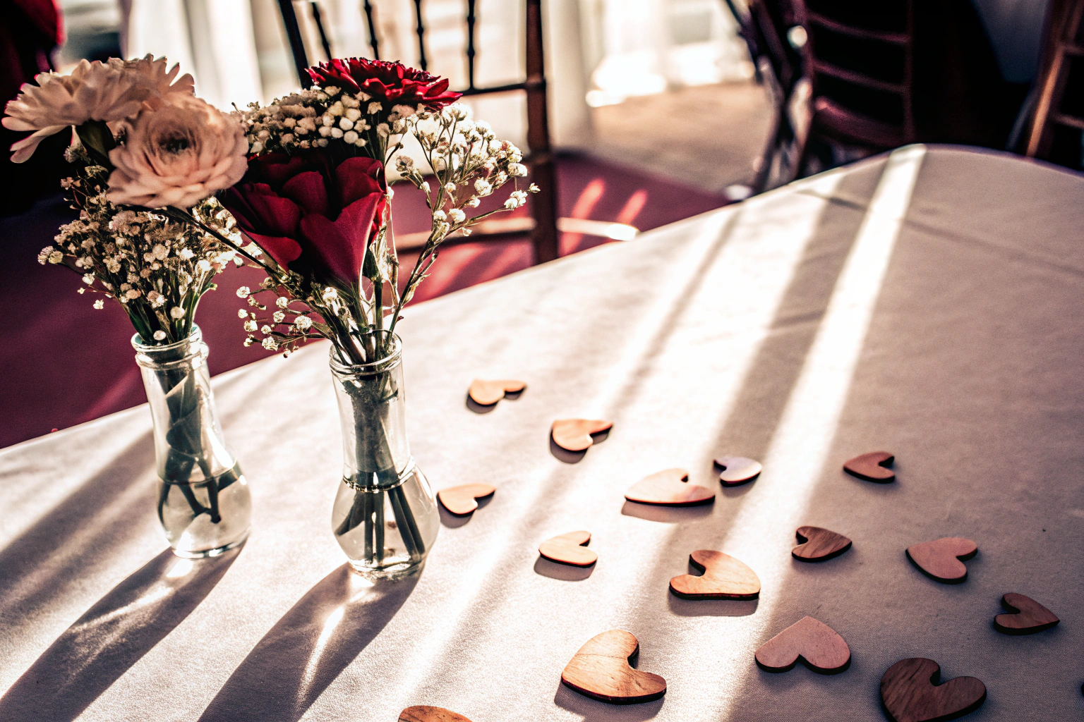 Detailaufnahme einer Babyshower Tischdeko mit Holzkonfetti und Blumen. Babyshower Tischdeko aus Holz