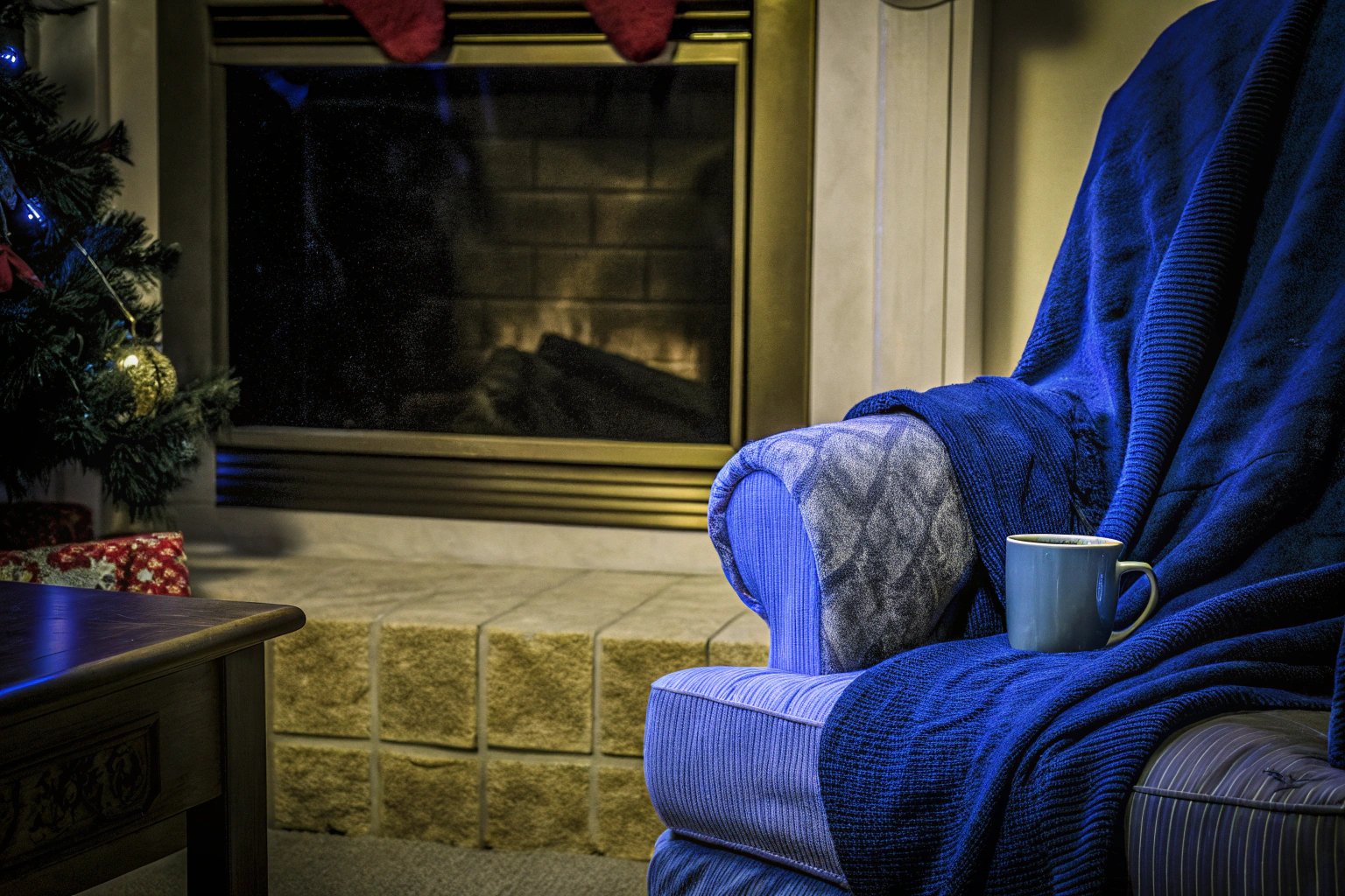 Ein gemütliches Wohnzimmer mit einem flauschigen Deckenpullover und einer heißen Tasse Tee, perfekt für kalte Winterabende. Gemütliches Wohnzimmer mit Deckenpullover