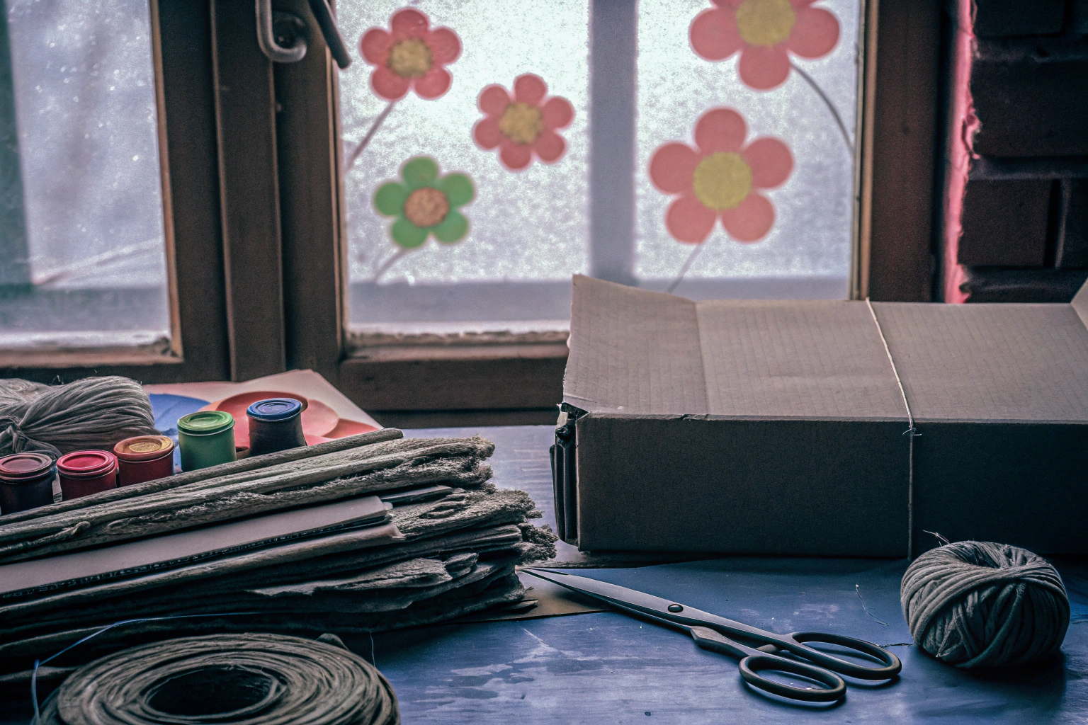 Ein Kind, das am Tisch mit recycelten Materialien bastelt. Kind bastelt mit recycelten Materialien
