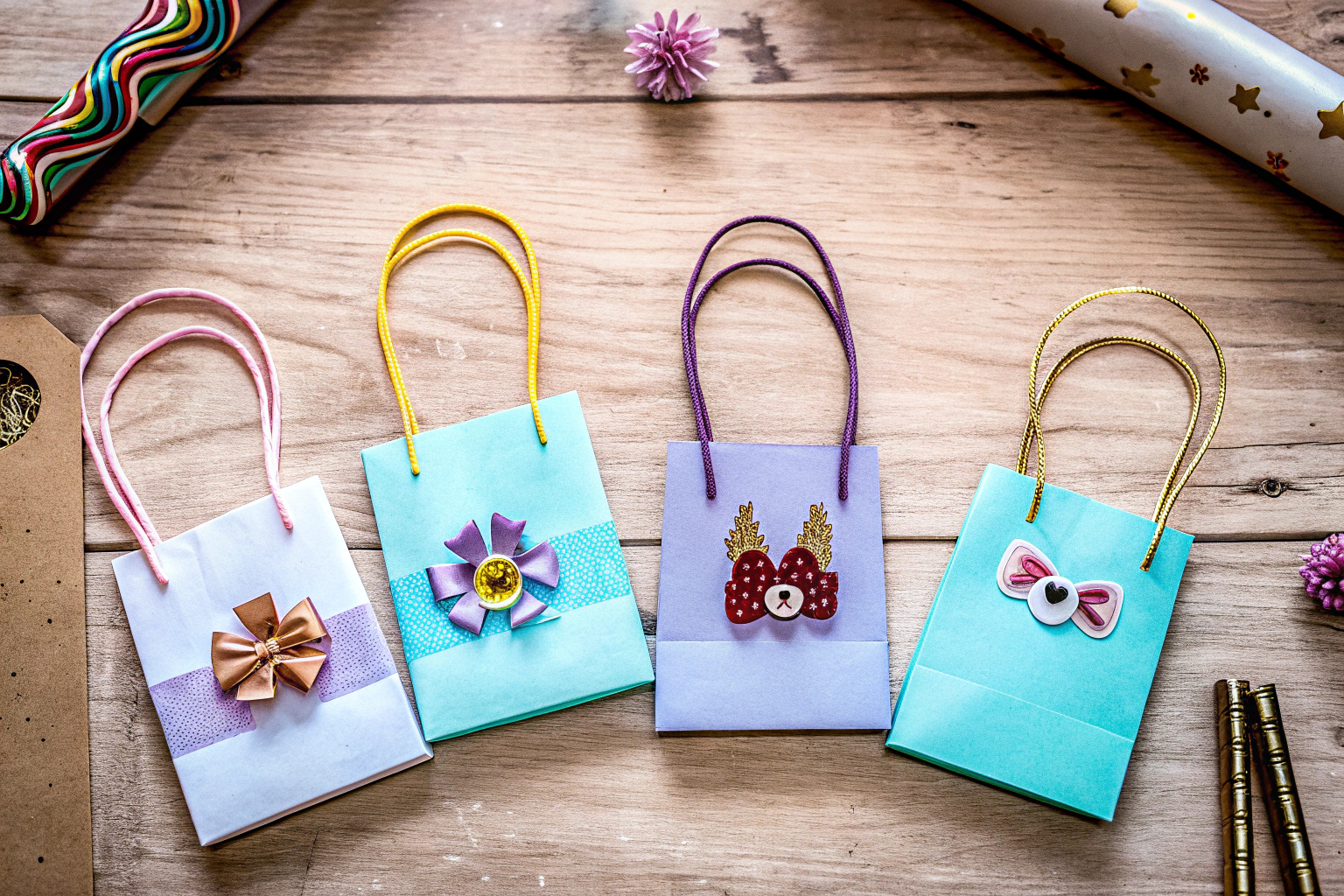 Eine Auswahl an bunten Geschenktüten, die mit verschiedenen Materialien wie Bändern und Aufklebern verziert sind. Bunte DIY Geschenktüten mit Verzierungen