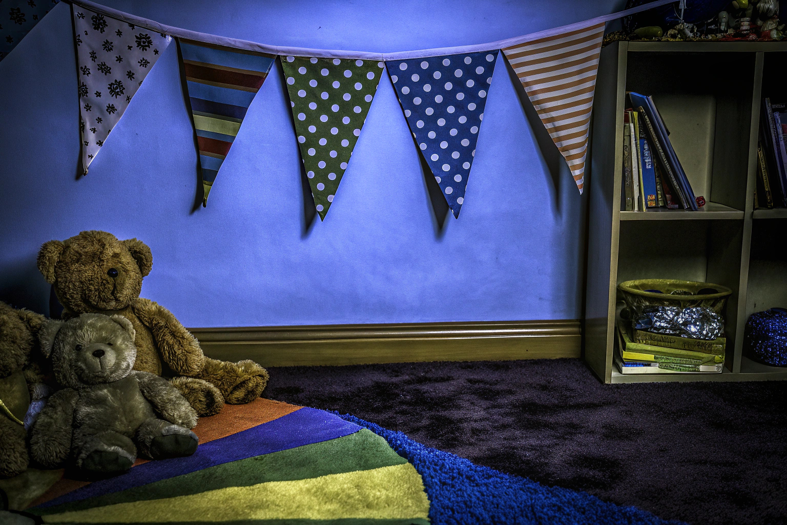 Eine bunte Wimpelkette, die in einem Kinderzimmer von der Decke hängt. Bunte Wimpelkette im Kinderzimmer