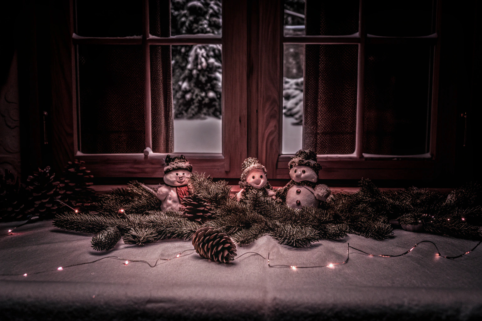 Eine festliche Tischdekoration mit Schneemann-Figuren und Tannenzweigen. Festliche Tischdekoration mit Schneemann-Figuren