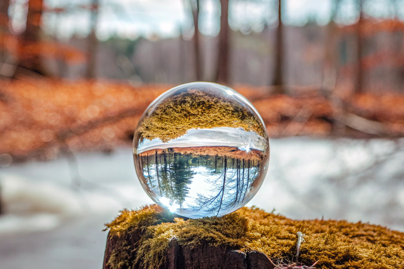 Eine Glaskugel wird genutzt, um eine Landschaftsaufnahme mit verzerrter Spiegelung zu machen. Glaskugel Fotografie