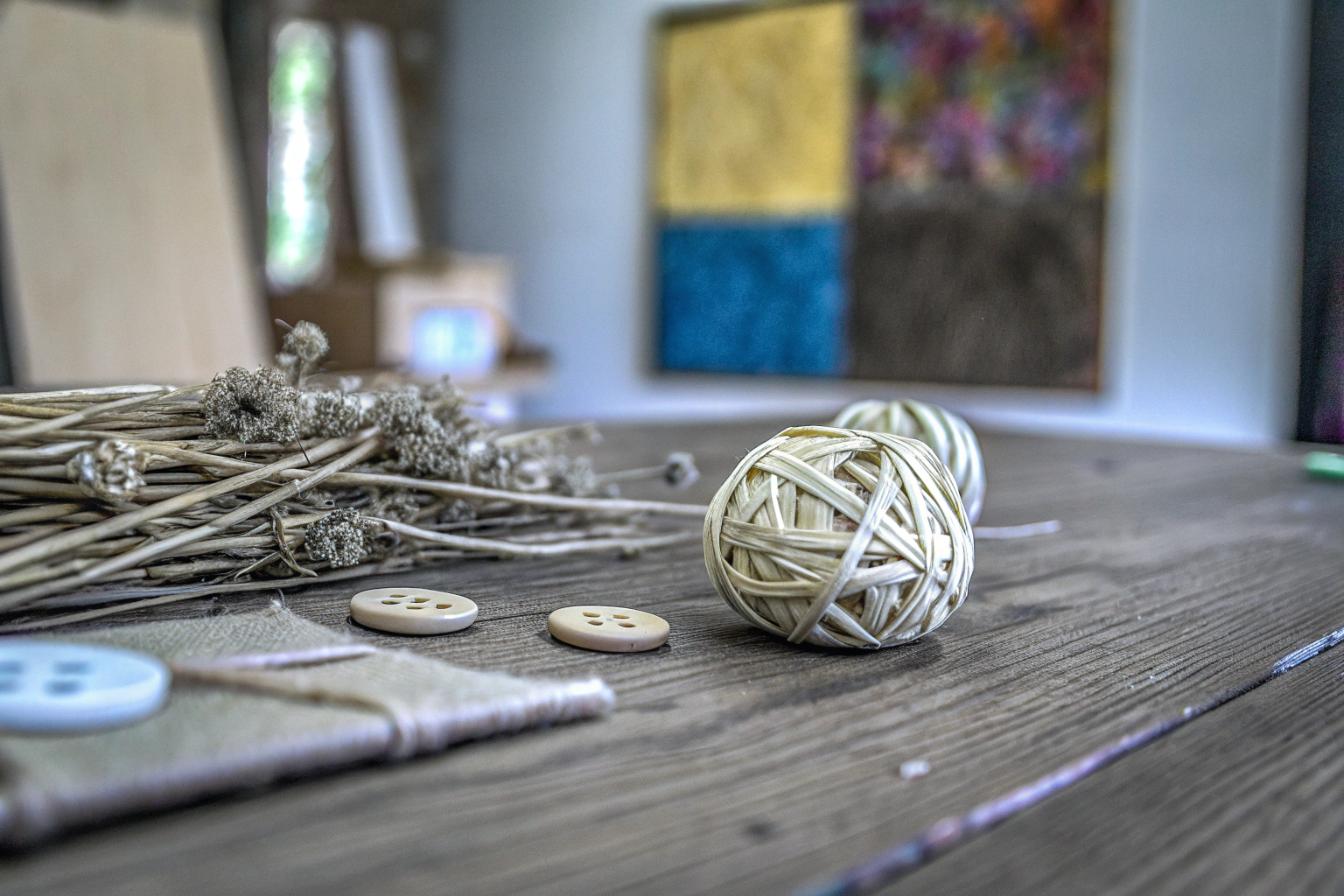 Eine kreative Bastelstation mit verschiedenen nachhaltigen Materialien wie Rattan, Trockenblumen und Holzknöpfen. Bastelstation mit nachhaltigen Materialien