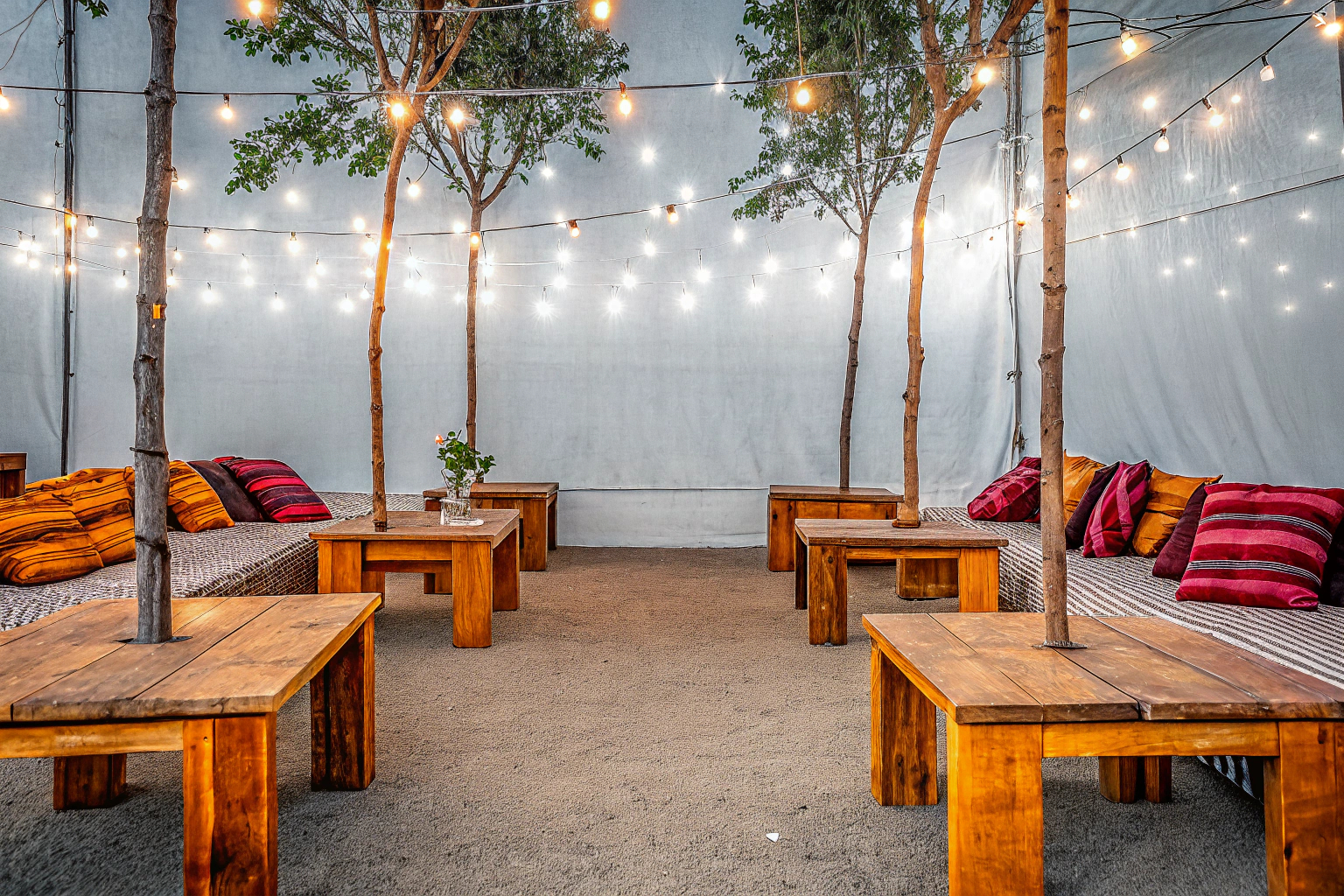 Eine stimmungsvoll beleuchtete Gartenparty bei Nacht mit LED-Lichterketten und Kerzen. Gartenparty Beleuchtung