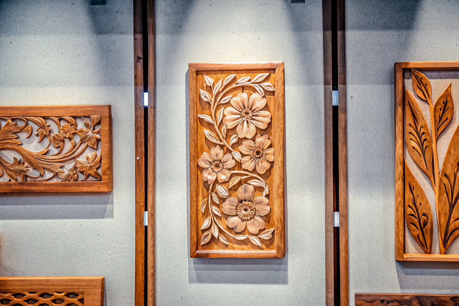 Holzkunstwerke mit floralen Designs an der Wand, die eine natürliche und elegante Atmosphäre schaffen. Holzkunstwerke im Boho-Stil