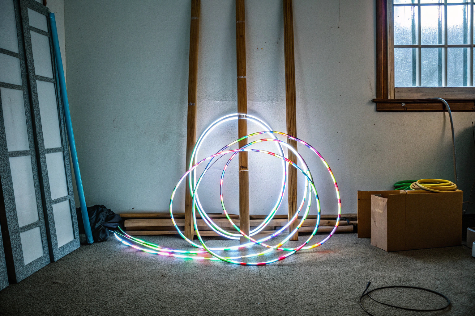 Kinder spielen mit leuchtenden LED Pop Tubes in einem abgedunkelten Raum. Kinder mit LED Pop Tubes