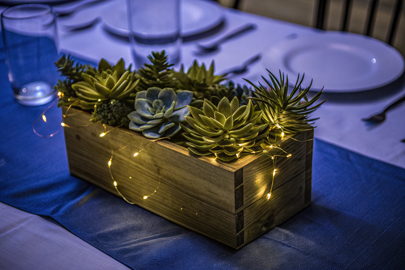 Künstliche Sukkulenten in Holzkiste mit LED-Licht als Tischdekoration. Künstliche Sukkulenten mit LED-Licht