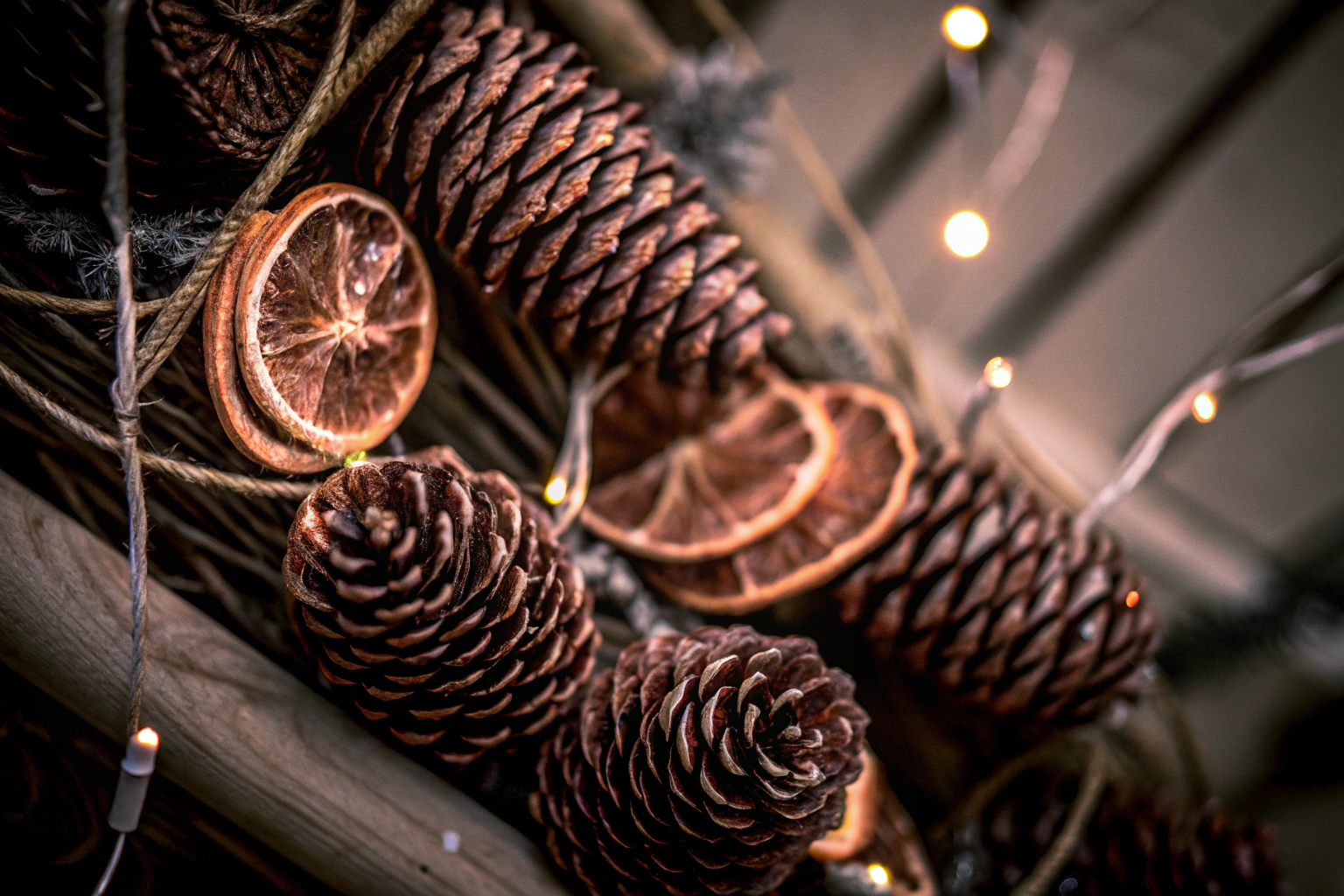 Nahaufnahme von handgefertigten Weihnachtsdekorationen aus natürlichen Materialien wie Tannenzapfen und getrockneten Orangenscheiben. Nachhaltige Weihnachtsdekoration