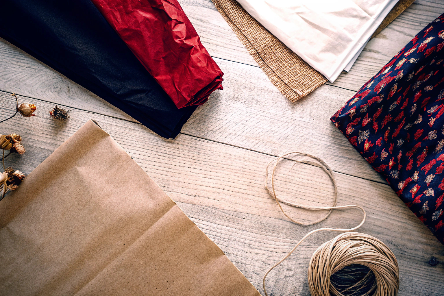 Verschiedene nachhaltige Verpackungsmaterialien wie Papier, Stoffbeutel und Jute. Nachhaltige Verpackungsmaterialien
