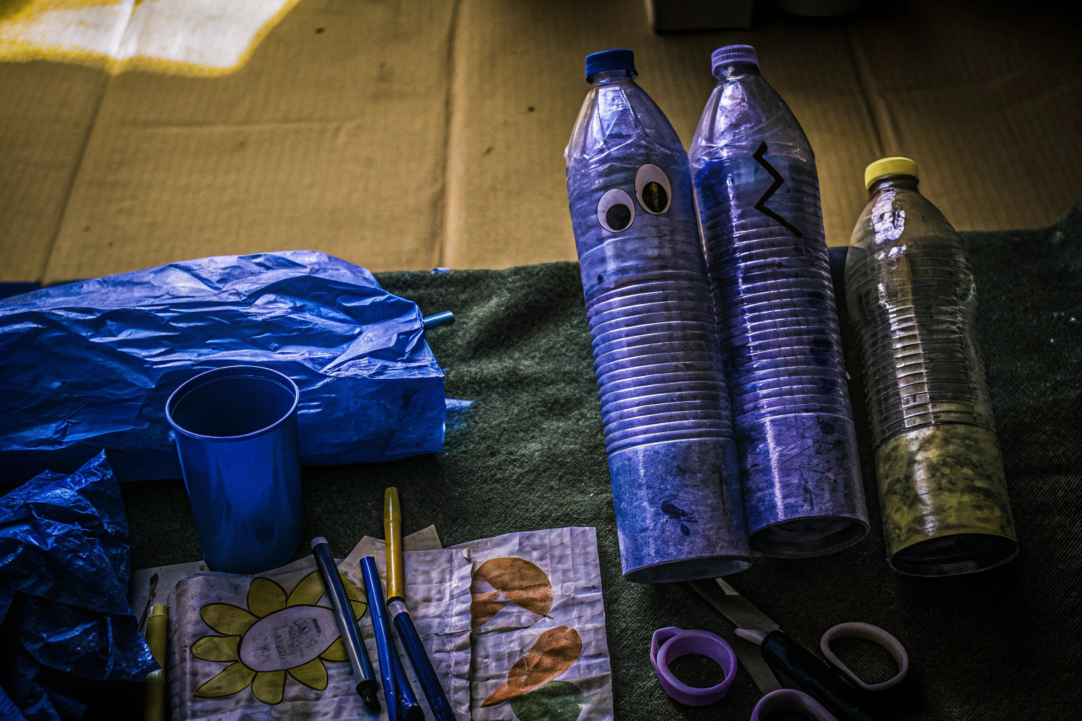 Verschiedene recycelte Materialien wie Plastikflaschen, Dosen und alte Zeitungen, die für Bastelprojekte verwendet werden können. Recycelte Materialien für Bastelprojekte